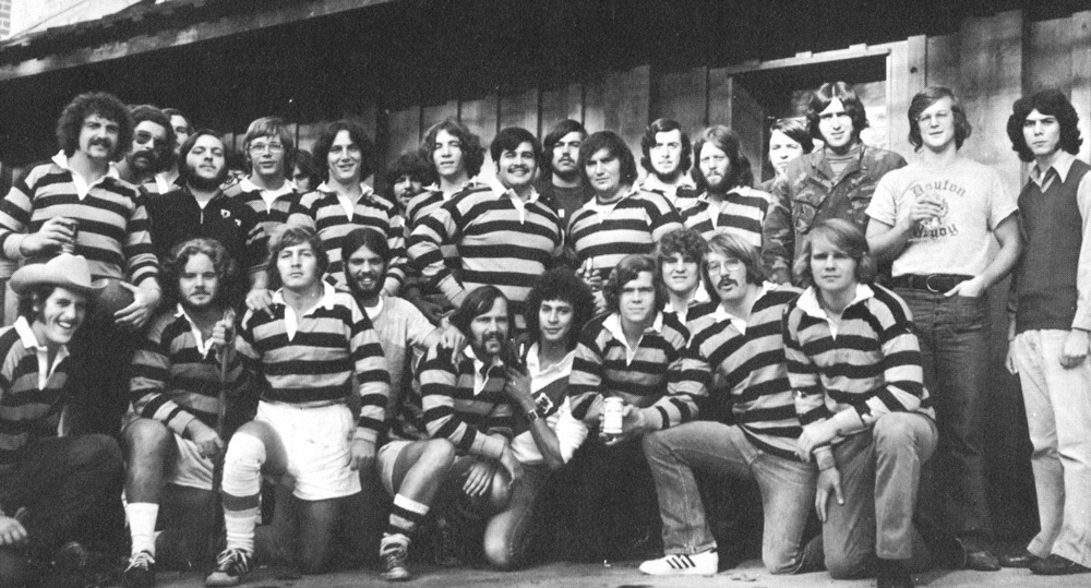 The rugby team in striped shirts poses for a photo