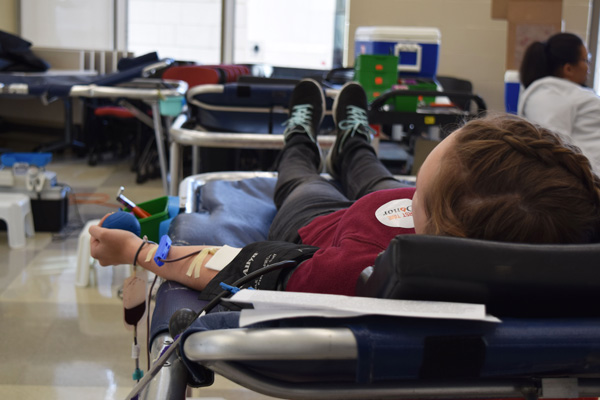 student lies on a table to donate blood