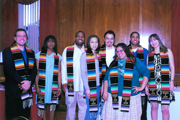 Students stand in brightly colored stoles