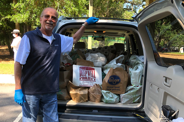 Rich Miskewicz stands in front of a car full of donated items