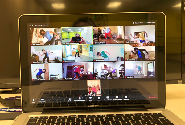 Images on a computer screen of dance students warming up.