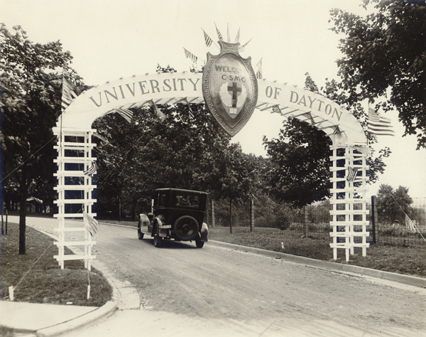 Car drives under an archway with the university of dayton name