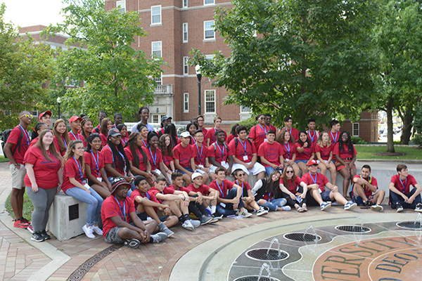 Students in red T-shirts pose near the fountain in Central Mall