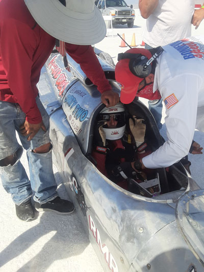 Jimmy Wollenberg gets strapped into his roadster before the race.