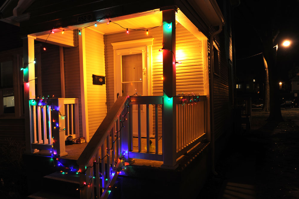 Christmas lights strung up the pillars of a porch