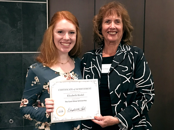 Student and professor hold a scholarship award 