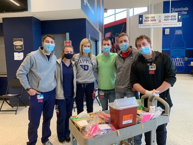 Six students inside in masks, ready to help patients