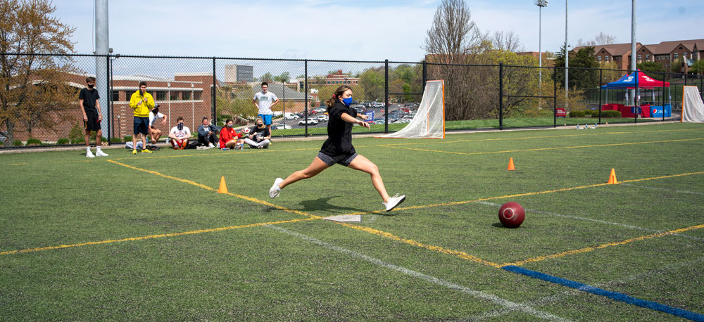 A student runs up to kick a kickball