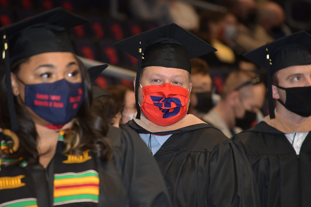 Graduate in a red Dayton Flyers face mask