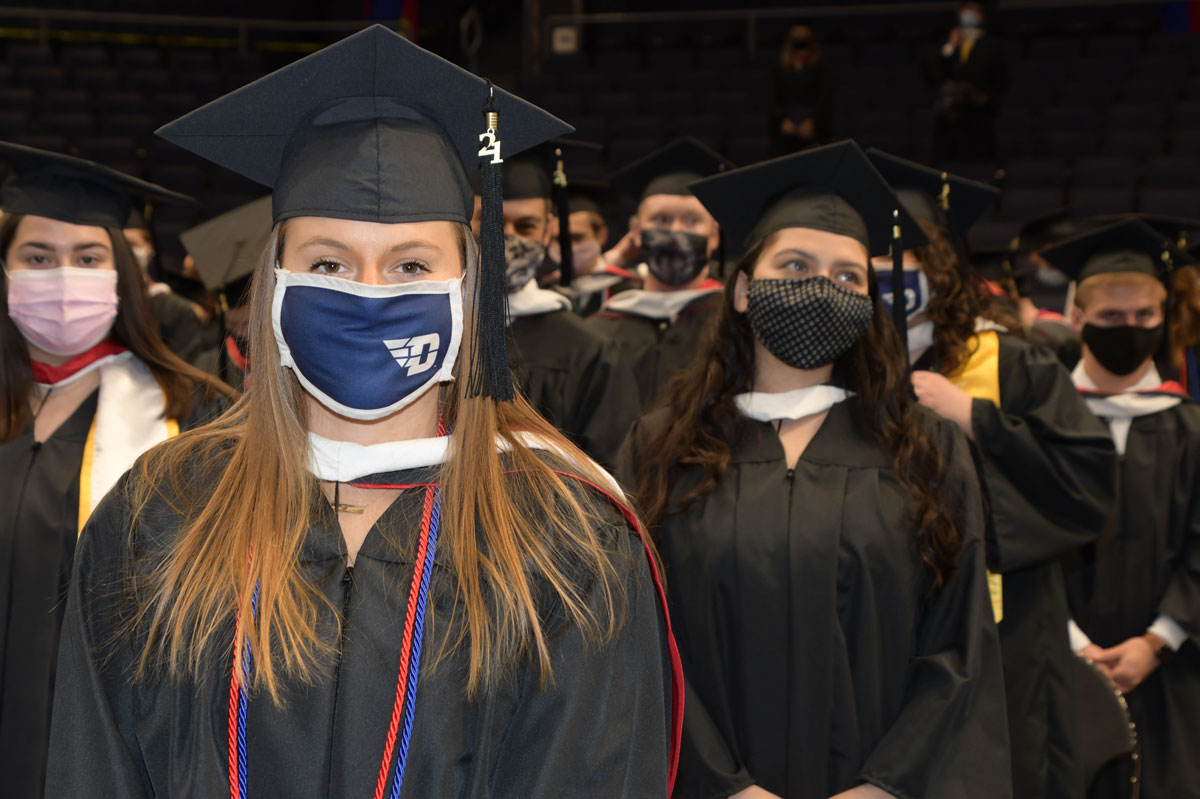 Graduate in a blue Dayton Flyers mask