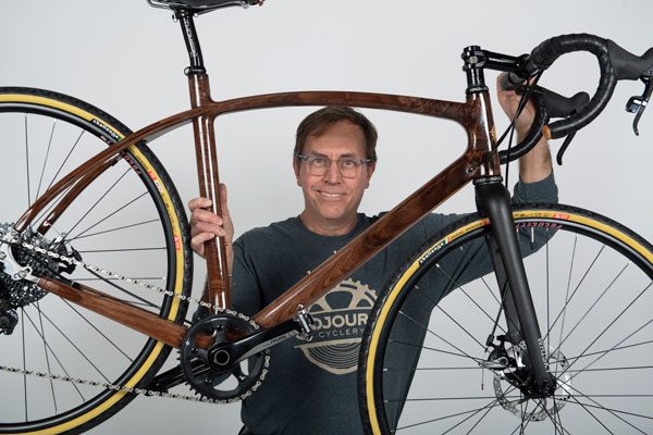 Jay Kinsinger holds his wooden bike