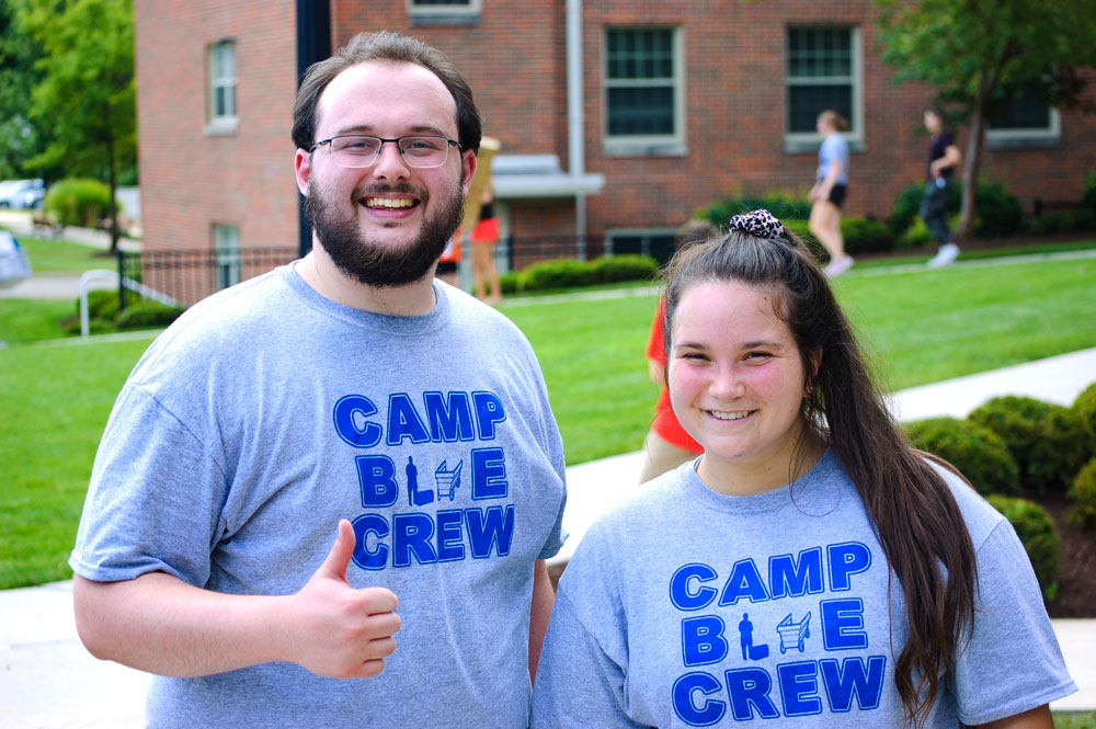 Two students in Blue Crew T-shirts smile