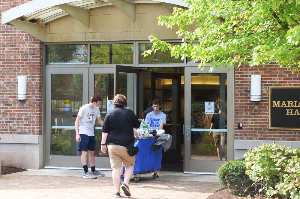 students push a cart into Marianist Hall