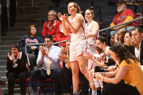 Players, coaches and staff on women's basketball on the bench