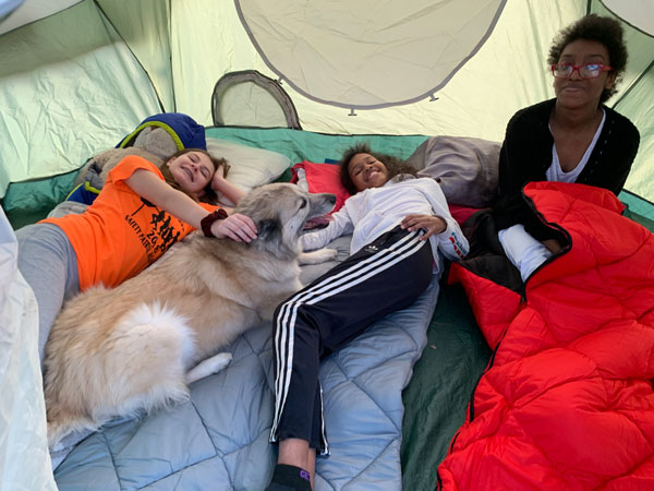 Three girls and a dog in a tent