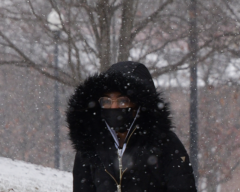 A student walks to class as snow falls