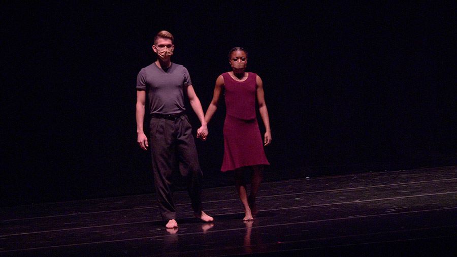 Two dancers performing a piece on stage.
