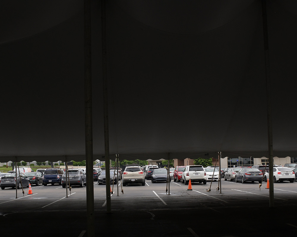 Cars and an event tent in a parking lot