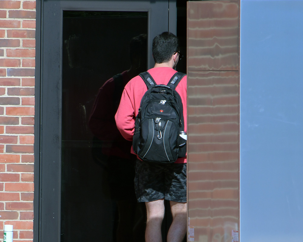 A student walks through a doorway