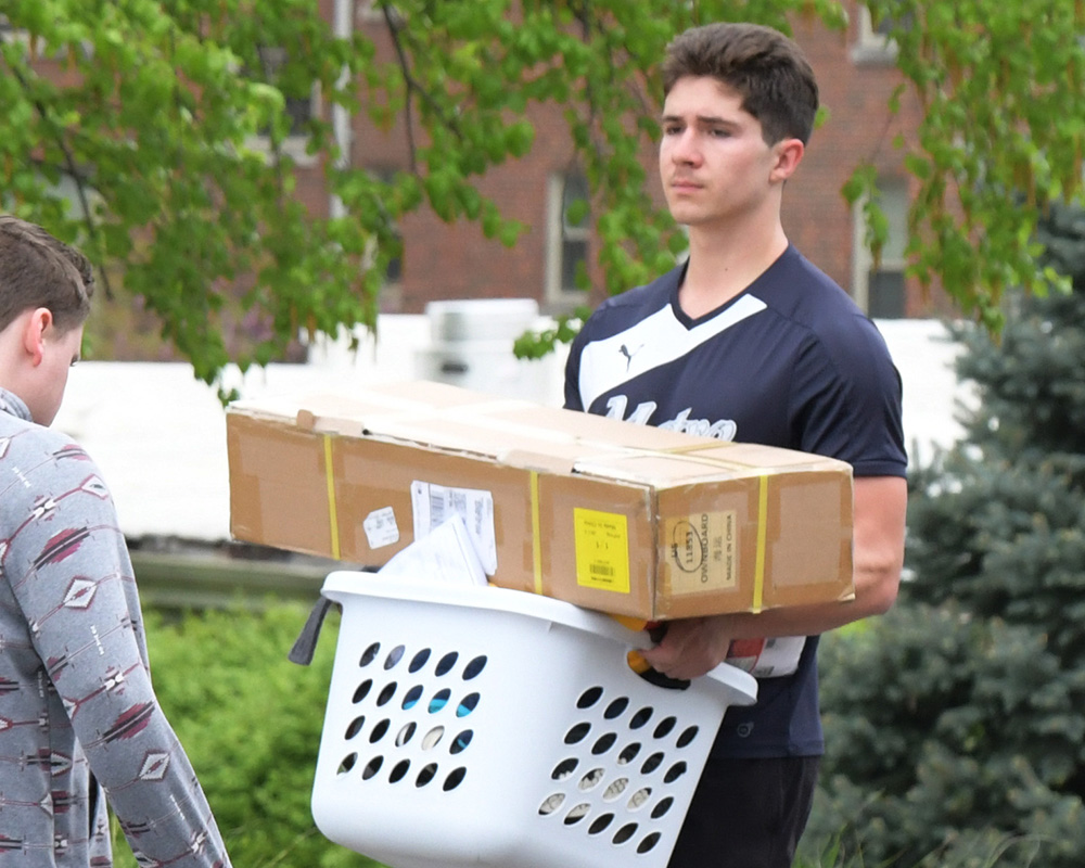 A student carries a load of belongings
