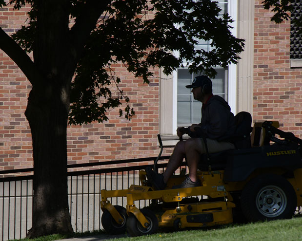 A  worker mows grass