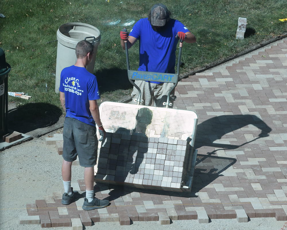 Workers install pavers