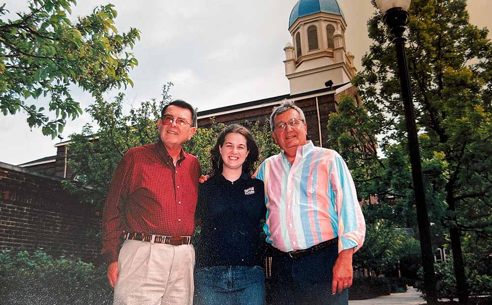 Elizabeth Buergler ’05 with her grandfather and uncle standing in front of the UD Chapel.