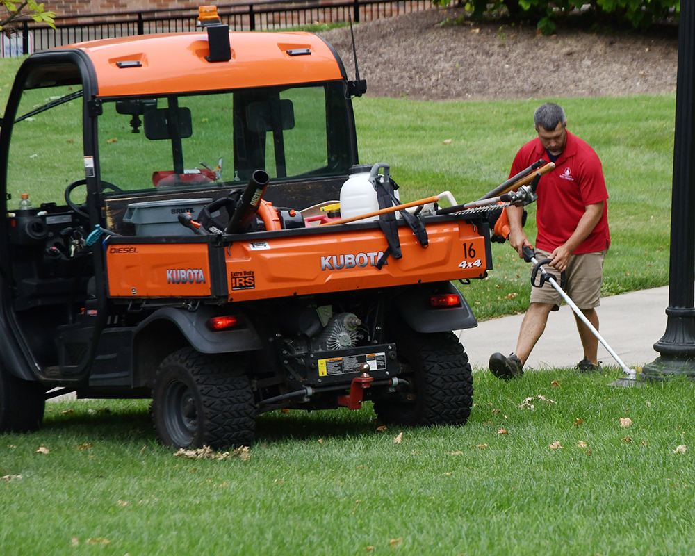 A worker trims the lawn