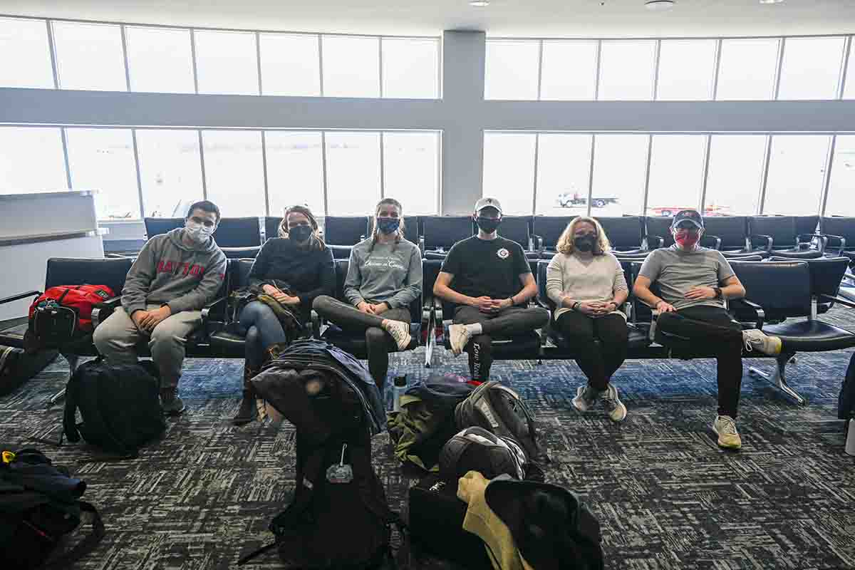 Group of students sit at the airport.