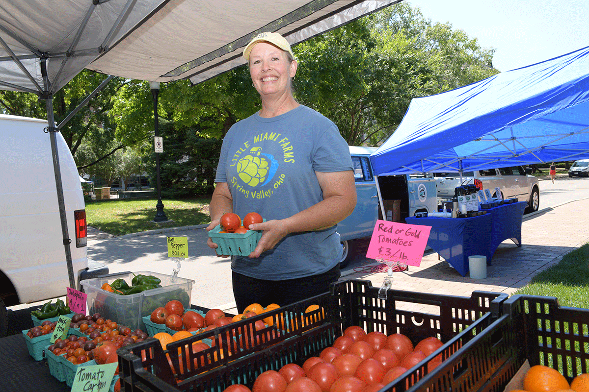 Woman hold tomatoes at the booth for Little Miami Farms