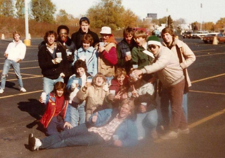 John Sutton '85 and his friends pose for a photo in a parking lot.
