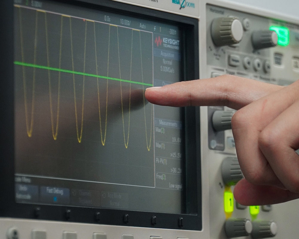 student points to an oscilloscope
