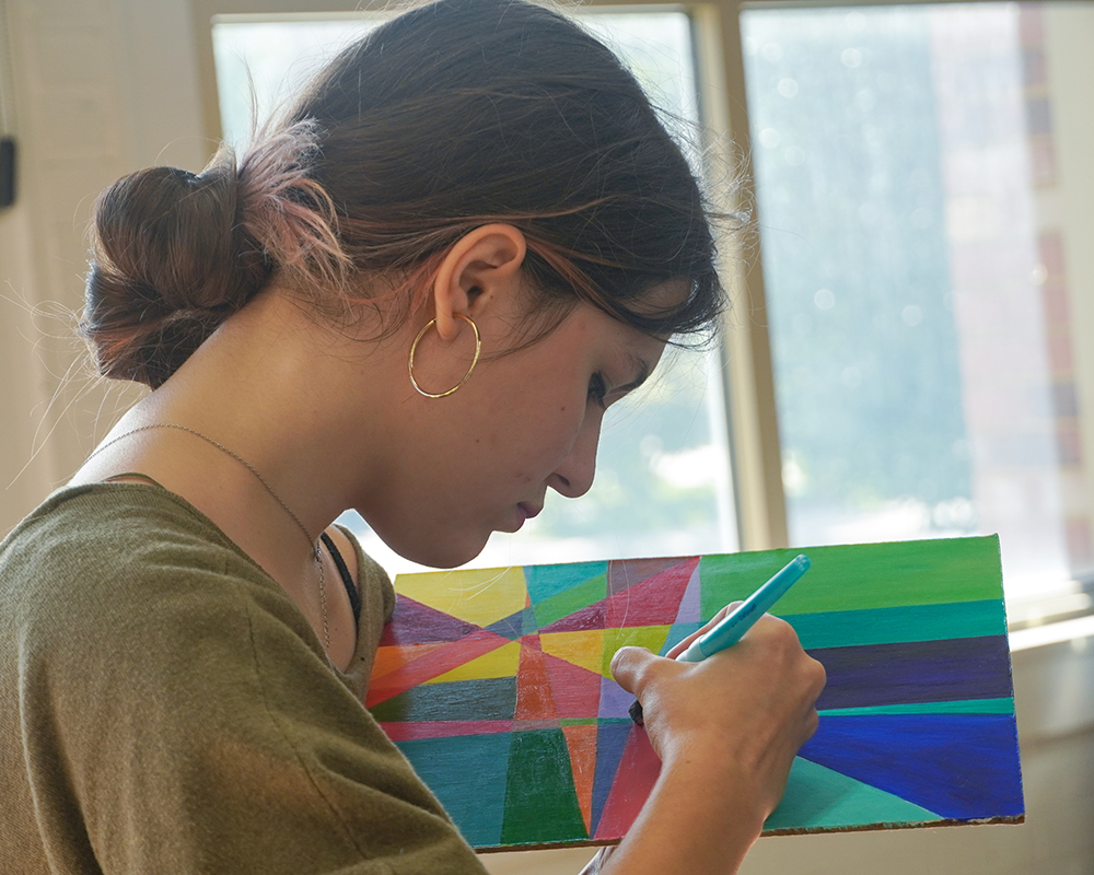 student works on a colorful painting
