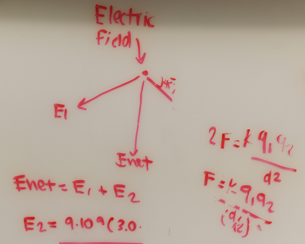 Math problems written in red on a dry erase board