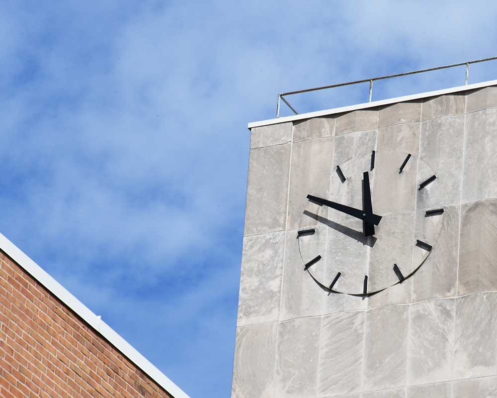 A clock on the side of Miriam Hall reads 11:49