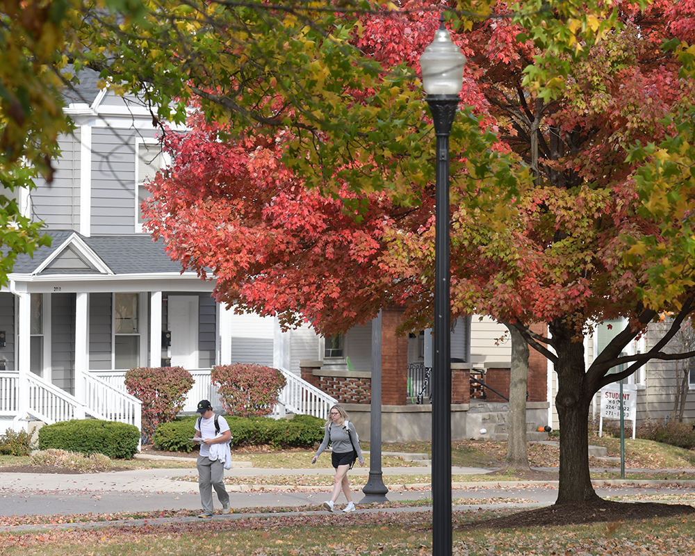 Students walk to class past colorful fall trees