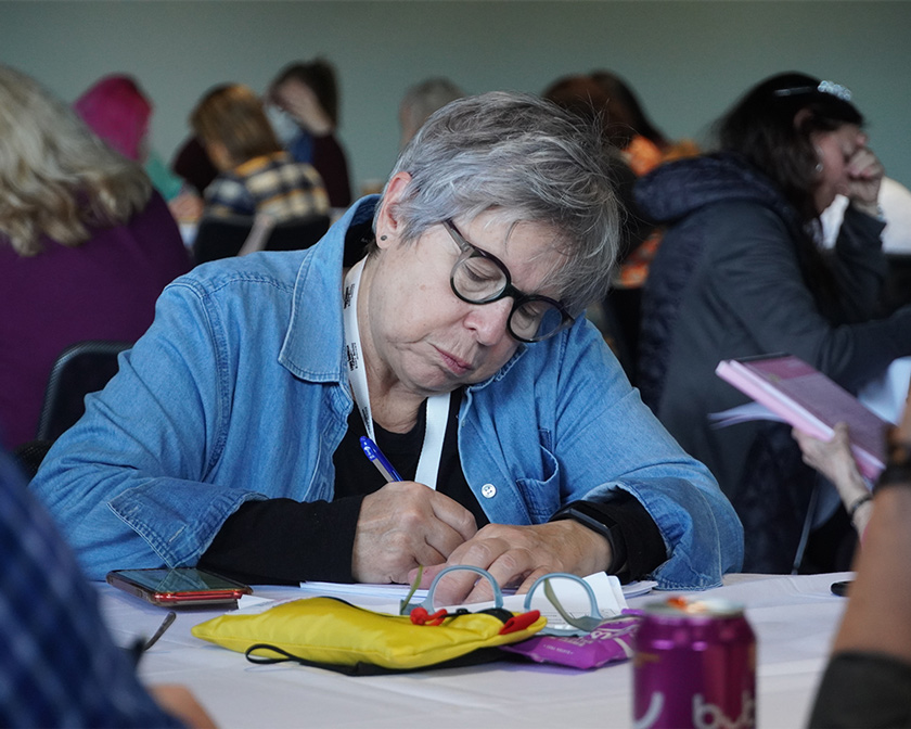 An attendee writes down notes during a session.