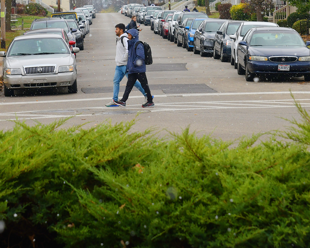 Two students walking in a crosswalk on a cold day