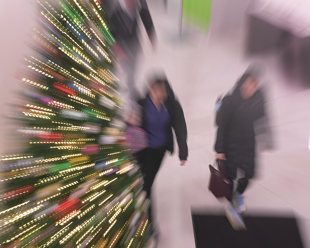 Students walk past a Christmas tree in the Roesch Library