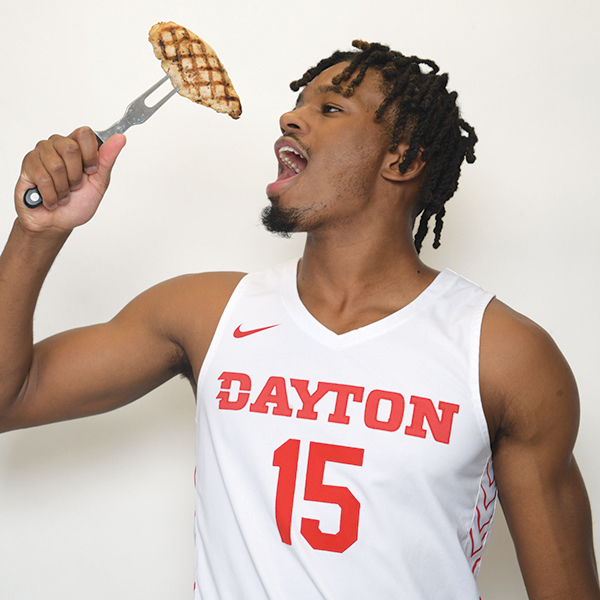DaRon Holmes gets ready to eat a chicken breast on a fork. 