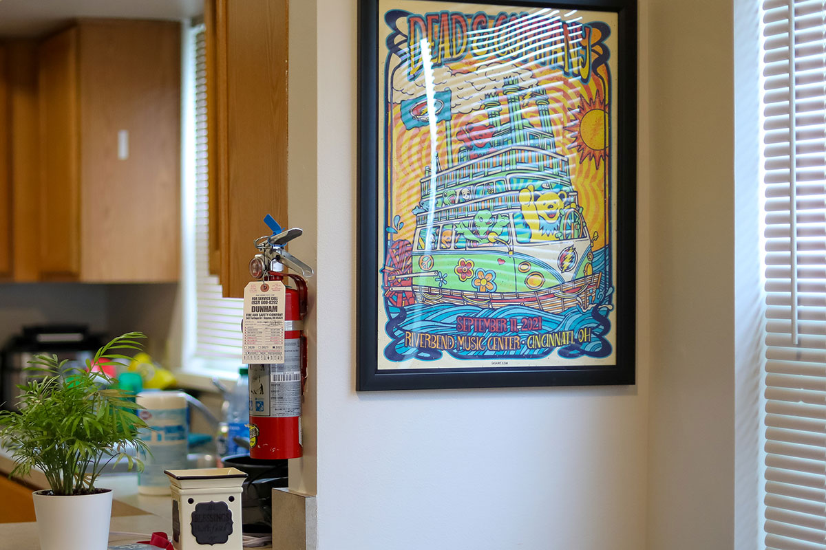 A framed band poster hangs by a dining room table.