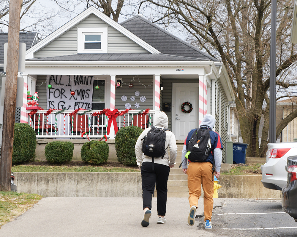 Students walk toward a decorated house