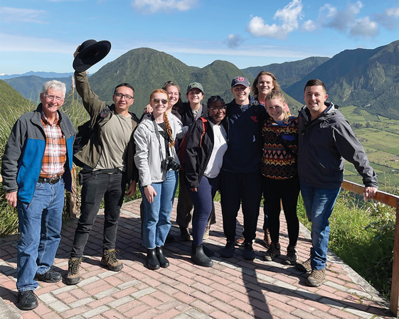 UD students pose in front of a mountain range in Ecuador.