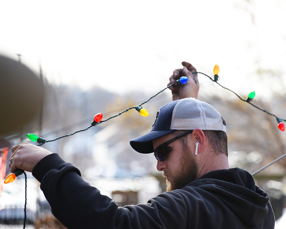 A worker handles a string of colorful Christmas lights