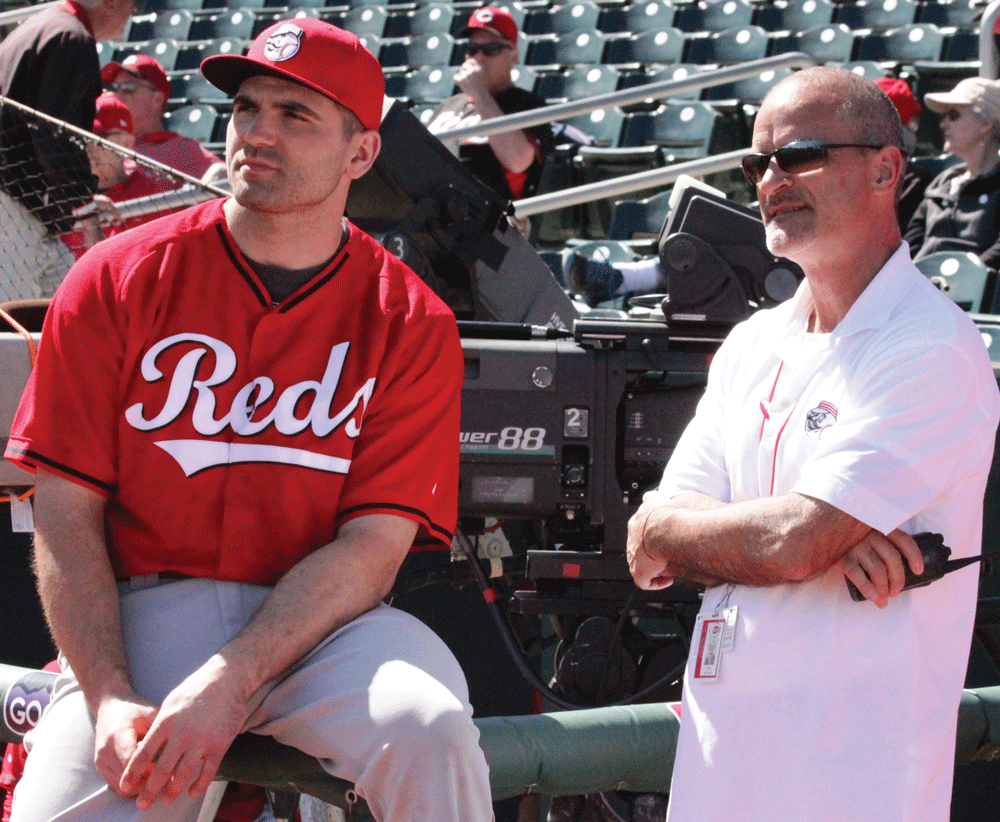 Rob Butcher stands on the field with Joey Votto.