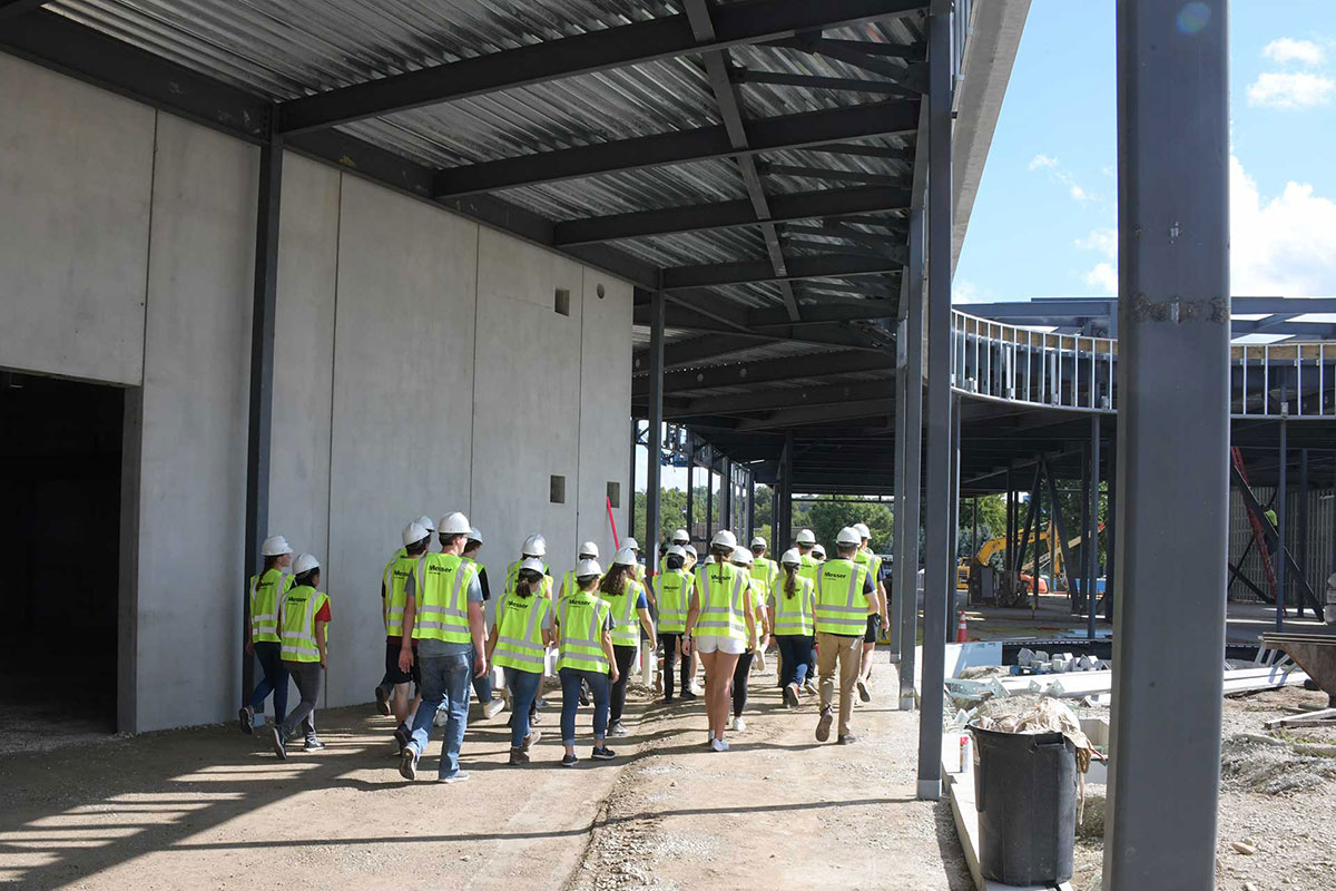 Students walk around construction site.