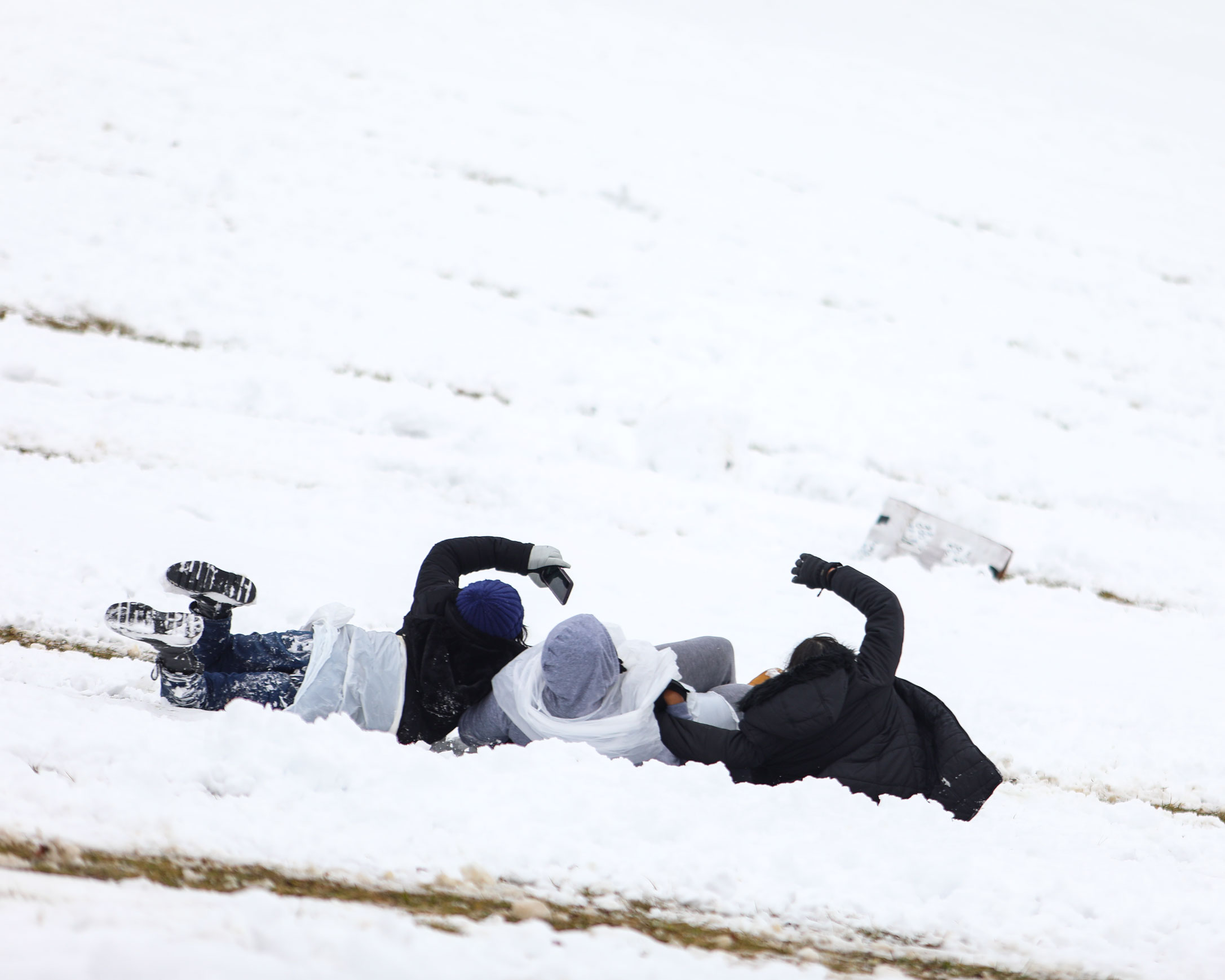 Three students sled down Stuart Hill