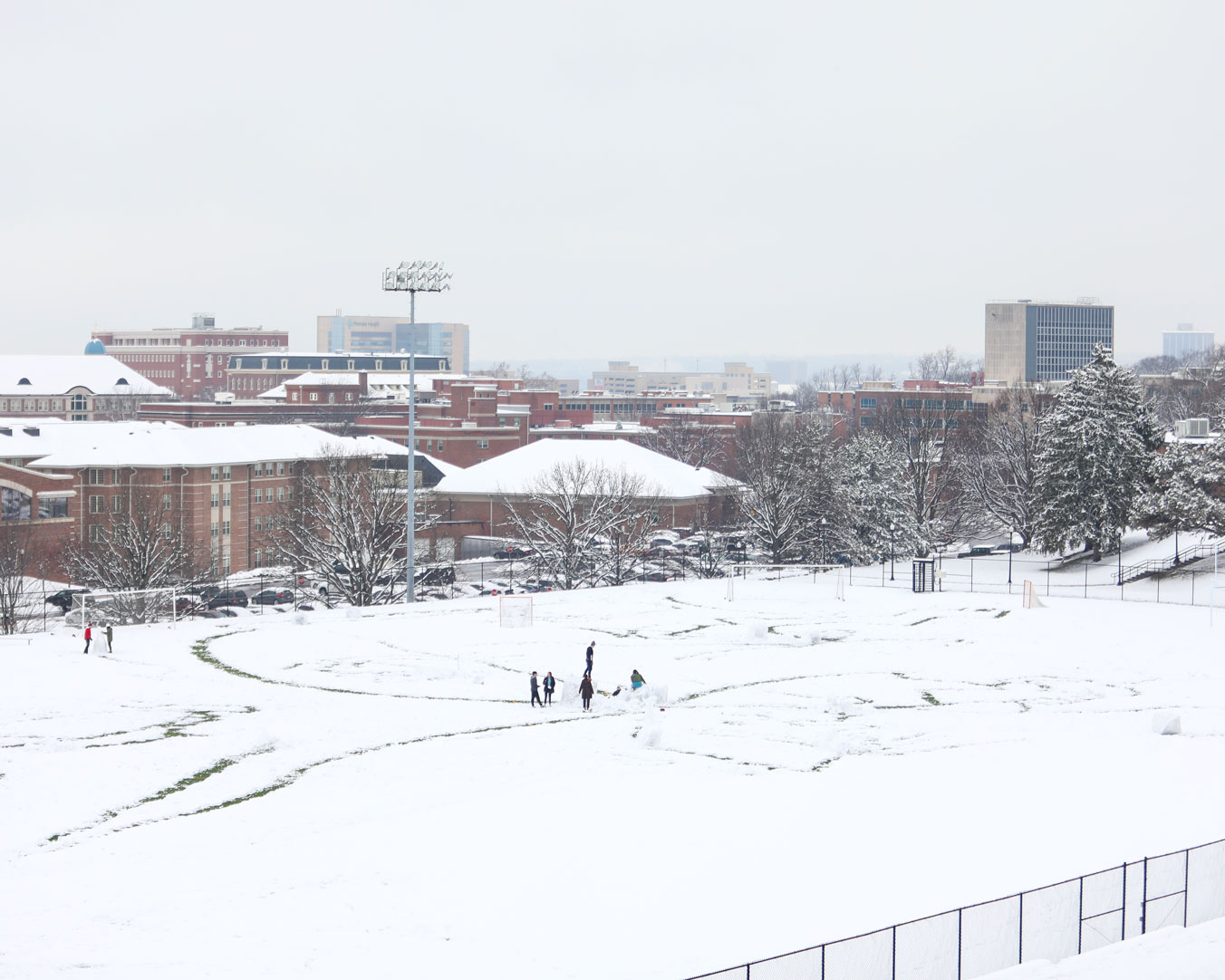 Students build a snowman on Stuart Field