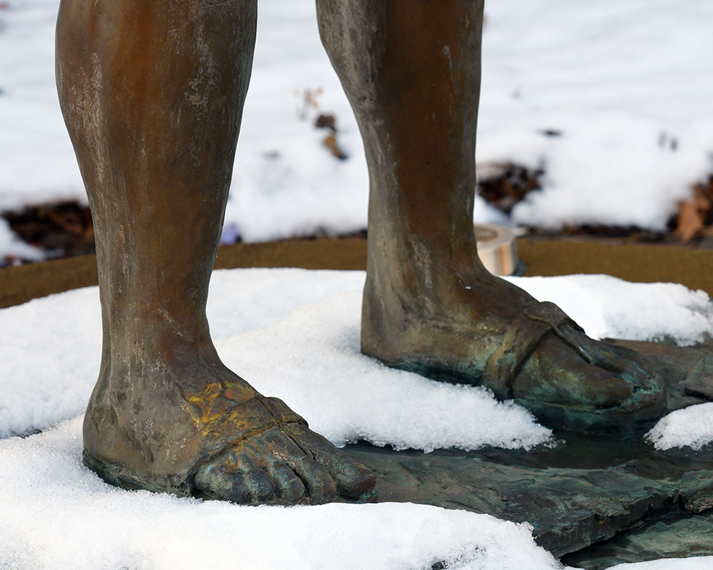 Snow surrounding the feet of a statue of St. Joseph