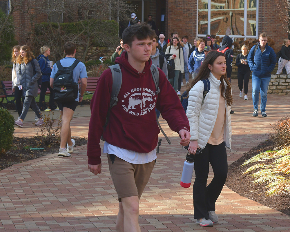 Students walk outside in shorts